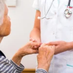 Old+ woman holding hands with nurse